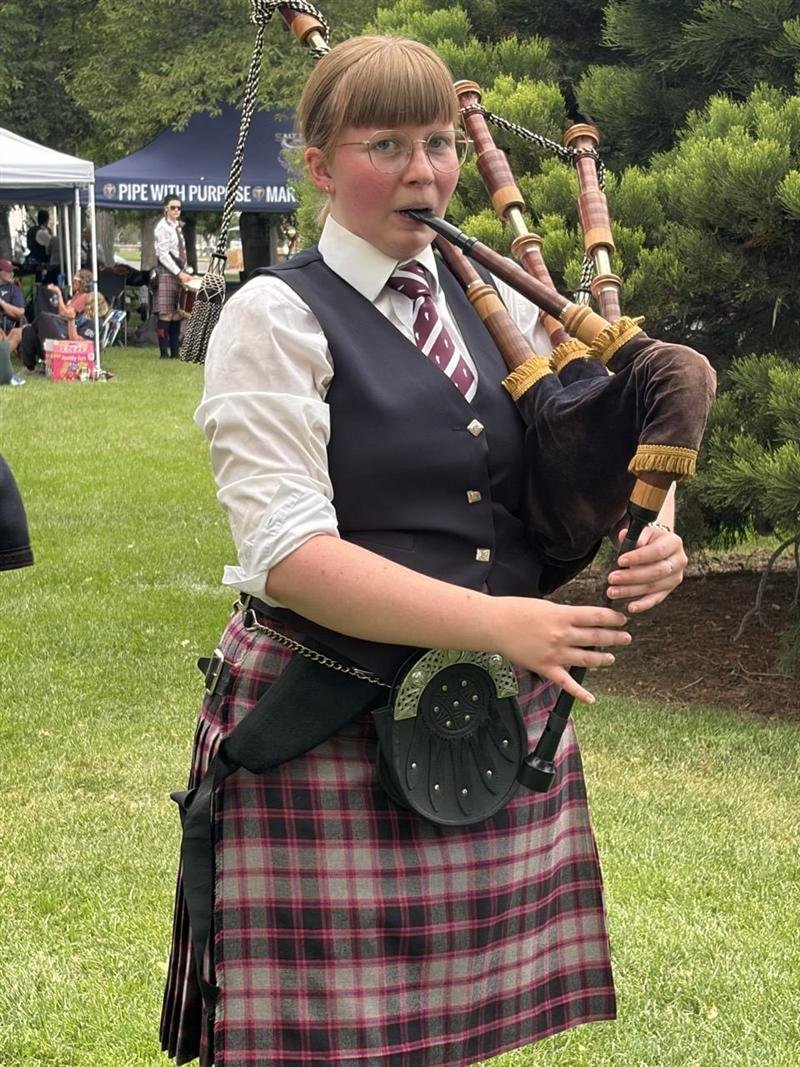 A piper playing on the grass